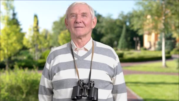 Pensionista caucásico con prismáticos al aire libre . — Vídeos de Stock
