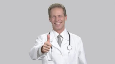 Başparmak gösterilmesini mutlu beyaz doktor.