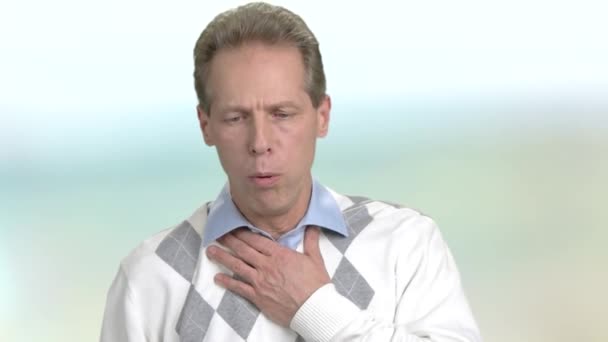 Mature man is coughing, blurred background. — Stock Video