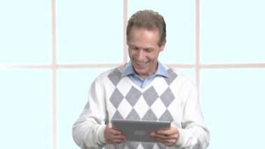 Mutlu adam eğleniyor tablet üzerinde oynama.