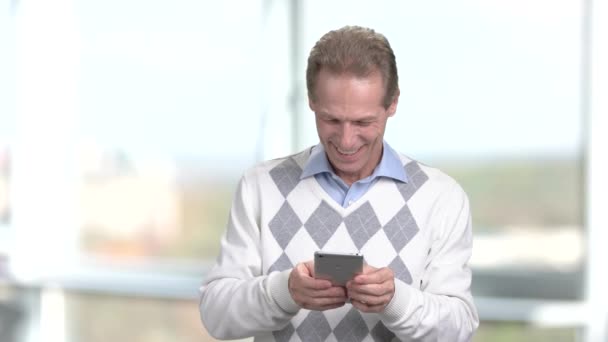 Sonriendo hombre maduro utilizando el teléfono inteligente . — Vídeos de Stock
