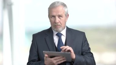 Yaşlı işadamı PC tablet üzerinde çalışan.