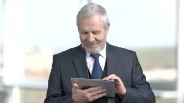 Gülümseyen kıdemli işadamı PC tablet kullanma.