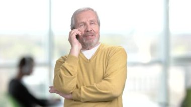 ihtiyar bir adamın cep telefonundan konuşuyor.