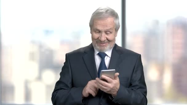 Smiling senior executive with smartphone. — Stock Video