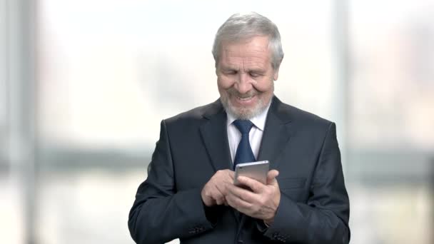 Leende äldre affärsman med smartphone. — Stockvideo