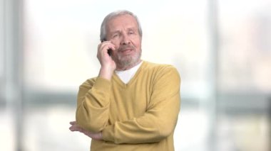 ihtiyar bir adamın cep telefonundan konuşuyor.