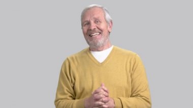 Kameraya konuşan yaşlı adam gülümseyen.