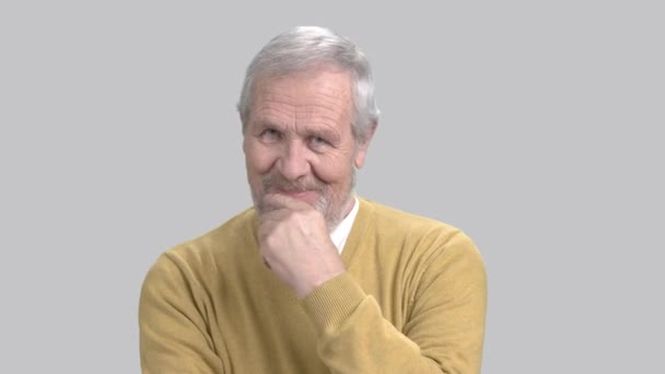 Smiling elderly man on grey background. — Stock Video