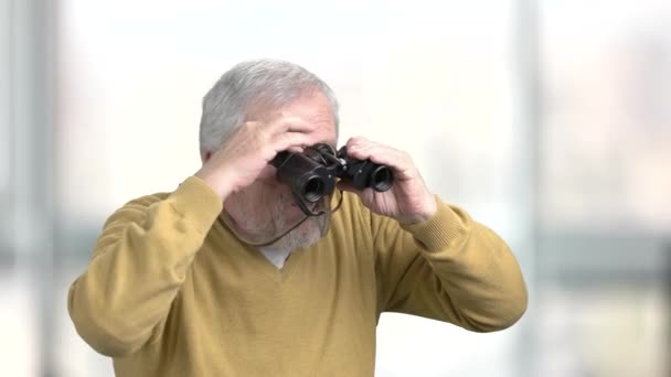 Grand-père regardant à travers les jumelles . — Video