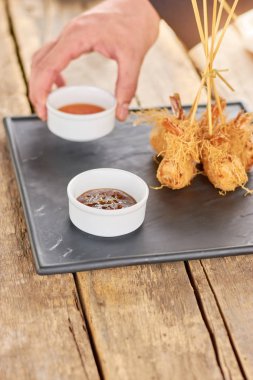 Şef el soslu çıtır karides için koyarak.