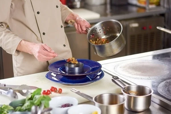 Chef manos poniendo verduras ratatouille en plato . — Foto de Stock