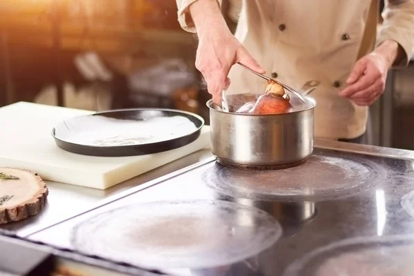 Chef sacando caña de cordero de la cacerola . — Foto de Stock