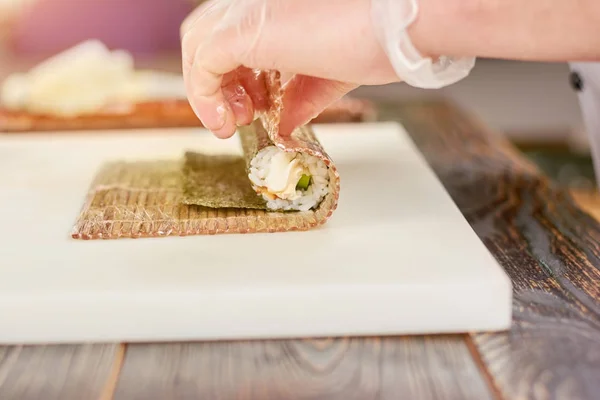 Manlig kock förbereder sushi rulle. — Stockfoto