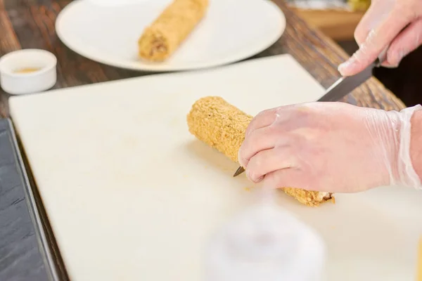Kocken händer med kniv skära sushi rulle. — Stockfoto