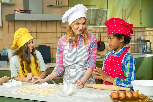 Jovem mulher e crianças cozinhar . — Fotografia de Stock