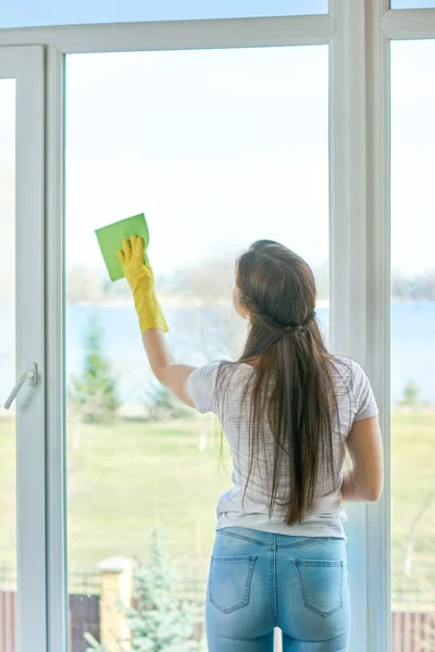 Junge Frau wischt Fenster ein. — Stockfoto