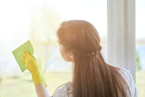 Een vrouw die een raam schoonmaakt. — Stockfoto