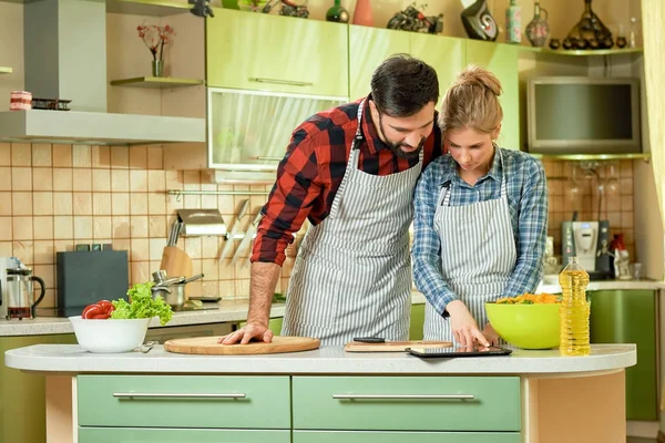 People with tablet in kitchen.