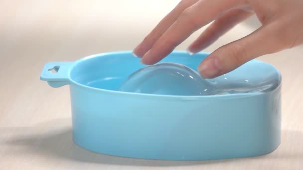 Hand placing in bowl with water, slow motion. — Stock Video