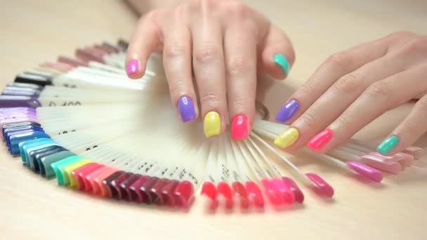 Mains à mouvement lent choisissant la couleur des ongles . — Video