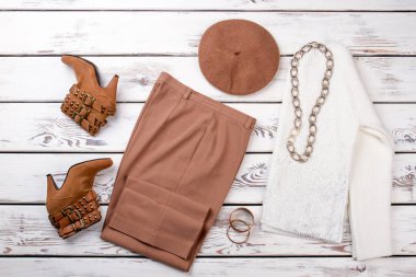 Kahverengi botları, pantolon ve şapka.