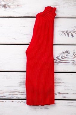 Katlanmış kırmızı yün kazak.