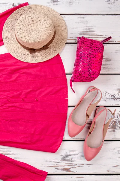 Womens garment: pink blouse, beach hat, purse and pink shoes.
