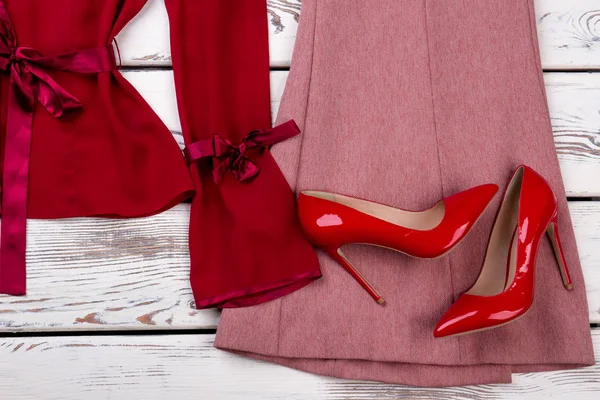 Close up red pair of heel shoes on clothes. — Stock Photo, Image