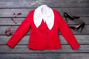 Süslü beyaz bluz, ceket ve makyaj aksesuarları.