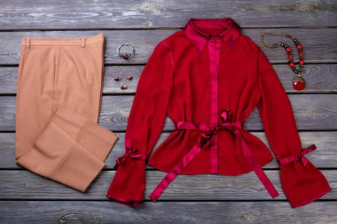 Kadın kahverengi pantolon ve kırmızı bluz.