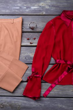 Düz yatıyordu kahverengi pantolon ve kırmızı bluz.