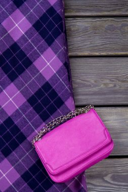 Top view purple handbag and checkered skirt. clipart