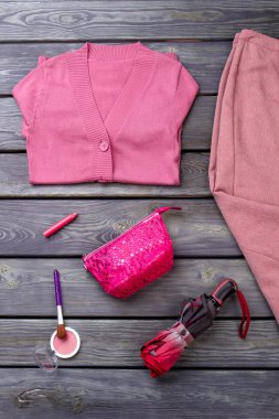 Pembe katlanmış kazak ve el çantası.