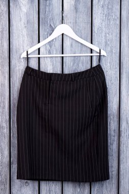 Siyah çizgili pantolon askı üzerinde katlanmış..