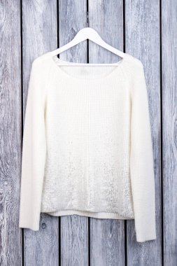 Beyaz yün kazak askı üzerine.