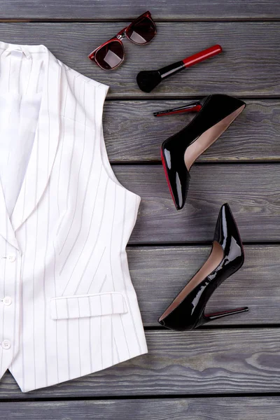 Beyaz kolsuz ceket ve aksesuarlar.