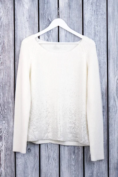 Beyaz yün kazak askı üzerine.