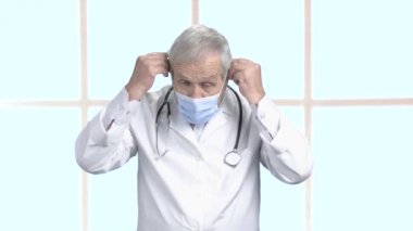 Kıdemli doktor koruyucu maske belirli bir konuma geçirme.