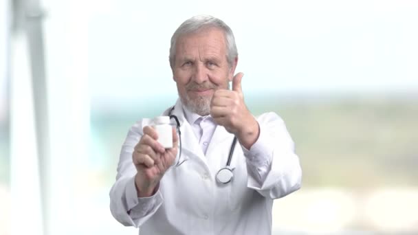 Mature souriant médecin offrant une pilule . — Video