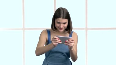Şirin komik kadın Smartphone oyun oynama.