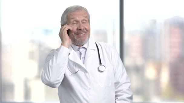 Cheerful caucasian doctor talking on phone. — Stock Video