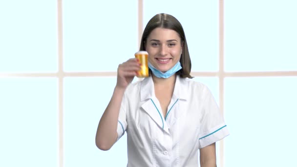 Lachende vrouw arts holding fles met pillen. — Stockvideo