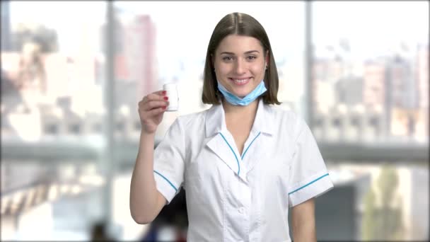 Charming young doctor holding pills. — Stock Video