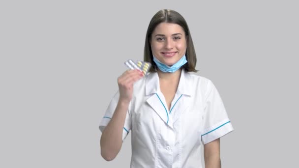 Joven sonriente médico femenino sosteniendo pastillas . — Vídeo de stock