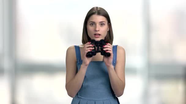 Young curious woman with binoculars. — Stock Video