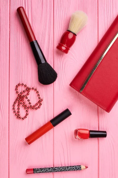 Weibliche rote Brieftasche und Make-up-Kosmetik. — Stockfoto