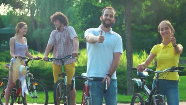 Pareja de jóvenes ciclistas mostrando los pulgares hacia arriba . — Vídeos de Stock