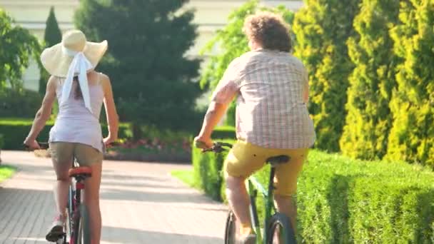 公園に乗って自転車に乗った若者のカップル. — ストック動画