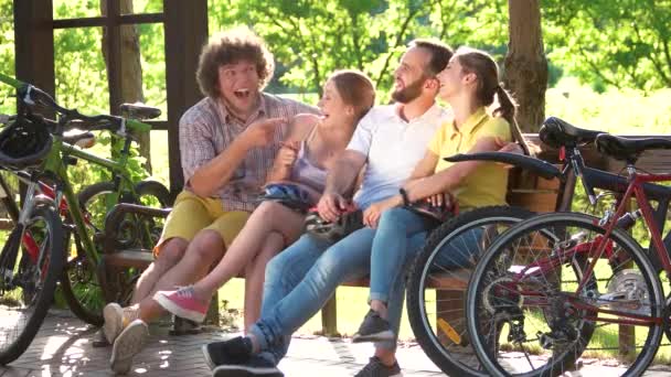 Jonge vrolijke vrienden rusten in park. — Stockvideo